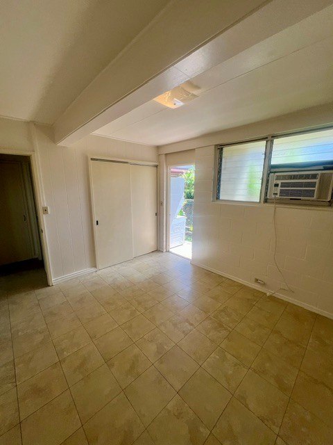 A room with a tiled floor and a window with blinds.